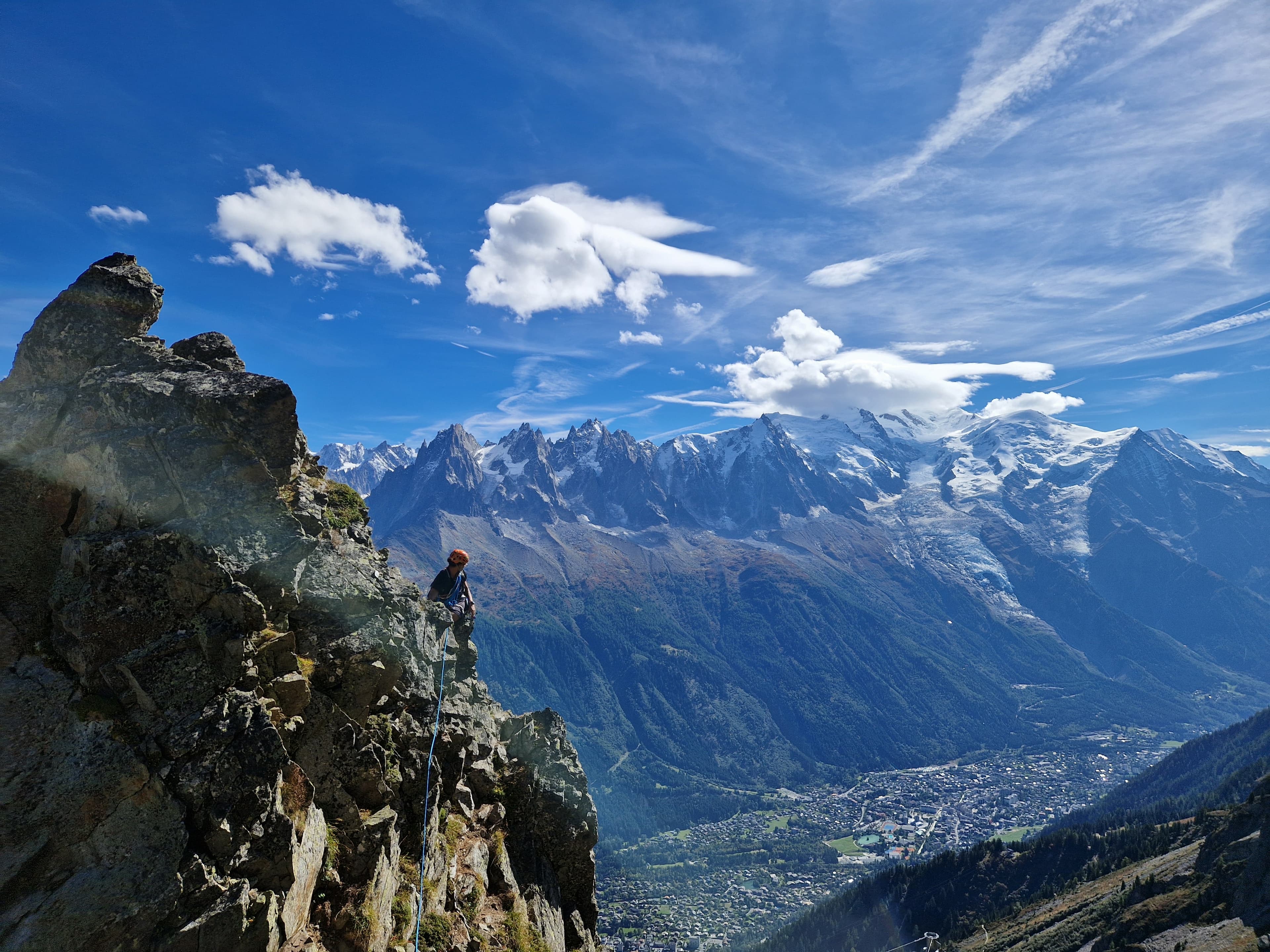 A climber on a mountain ridge above a valley